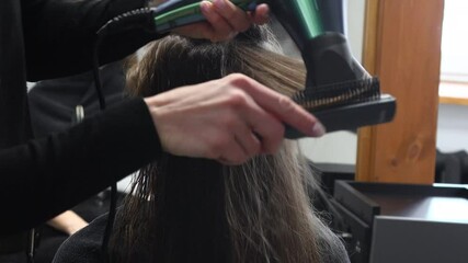 Poster - Master woman hairdresser dries the girls hair with a hairdryer after washing in a beauty salon.