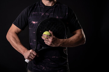 Man ready for paddle tennis serve in studio shot, anonymous pose