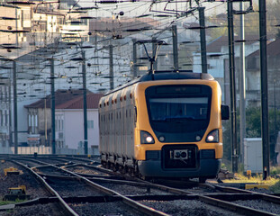 Poster - Freight train on the railroad with a cityscape in the background at sunrise