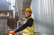 © Yaroslav Astakhov - Cheerful male worker wearing safety helmet, glasses and vest while standing near meta pipe and smiling