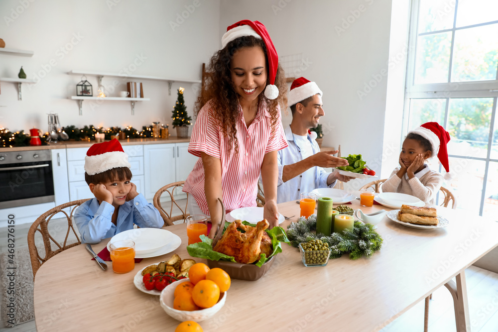 Happy family having Christmas dinner in kitchen