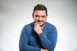 © arts - young positive man portrait in blue sweater at studio background