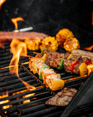 Wall Mural - Closeup on grilling sausages and meat with flame on a barbecue