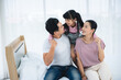 © chokniti - happy love family lifestyle with Asian father and mother and child daughter at home together