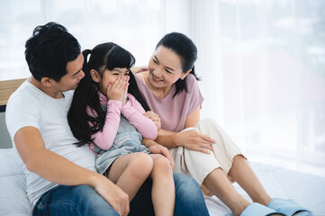 happy love family lifestyle with Asian father and mother and child daughter at home together