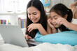© chokniti - education at home, young mother and child family learning to work a homework with laptop