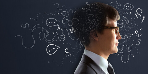 Poster - Portrait of attractive young european male on chalkboard wall background with arrows and thought icons sketch. Solution, direction, success and brainstorm concept.