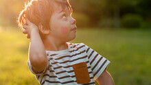 Boy With Painted Face, Surprise Looks To The Side, In The Summer In The Park