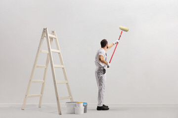 Wall Mural - Ladder and buckets in a room and decorator painting a wall