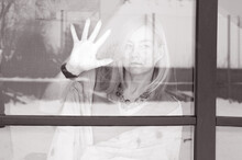 Portrait Of Woman Standing By Glass Window