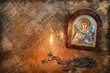 Icon of the Archangel Michael with silver and gilding, a pectoral cross and a burning candle.