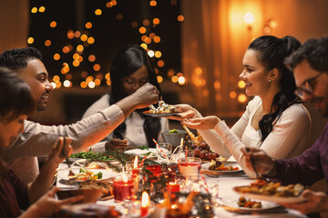 Wall Mural - holidays, party and celebration concept - multiethnic group of happy friends having christmas dinner at home