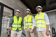 © Syda Productions - architecture, construction business and people concept - happy smiling male architects in helmets and reflective safety wests at office