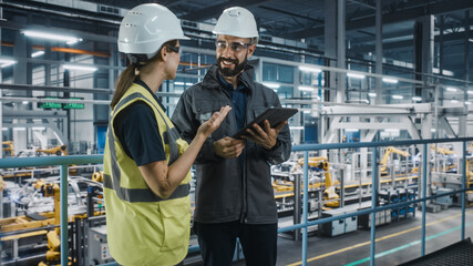Poster - Male Specialist and Female Car Factory Engineer in High Visibility Vests Using Tablet Computer. Automotive Industrial Manufacturing Facility Working on Vehicle Production. Diversity on Assembly Plant.