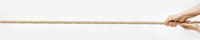 Tug Of War. Aged Wrinkled Hands Pull The Rope Towards Themselves. Horizontal Web Banner For Your Text.