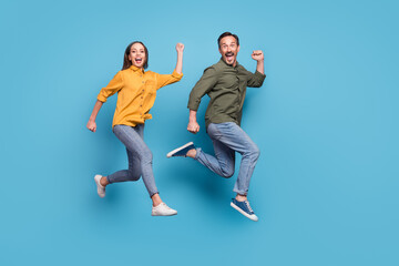 Poster - Full size profile photo of two delighted persons raise fists celebrate success triumph isolated on blue color background