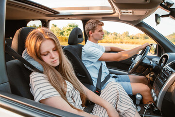 Wall Mural - young man driving car. woman sleeping with pillow