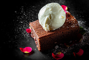 Chocolate Brownie cake with Vanilla Ice Cream on black plate