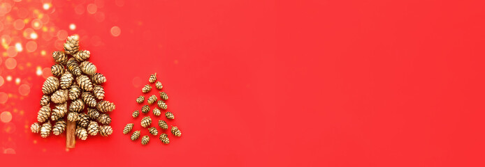 Wall Mural - New Year and Christmas card. Two decorative Christmas tree made from golden cones on a red background. Banner. Minimal New Year concept