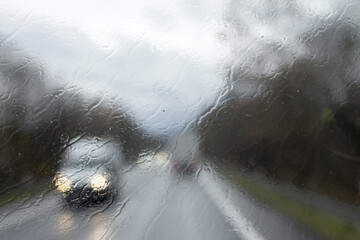 Poster - Driving with no windscreen wipers in heavy rain with oncoming traffic. Unwiped rain water off