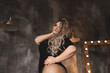 Plus-size woman with long blond hair in lingerie , overweight blonde with lush forms in the loft, full girl in black clothes with bright makeup