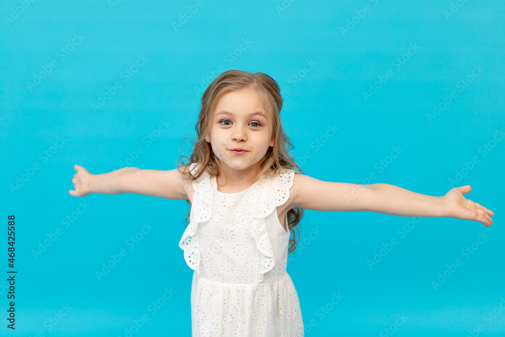 cute happy little girl in a cotton white dress on a blue background in ...