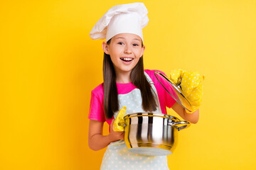 Photo of excited chef girl open saucepan check meal ready wear white apron hat isolated yellow color background