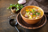 Fototapeta Na sufit - Czech food: Traditional Zelnacka cabbage soup with sausages and vegetables in a bowl on rustic wooden table. Copy space.