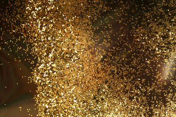 Gold (bronze) glitter shine dots confetti on black. Abstract light blink sparkle horizontal backgound.