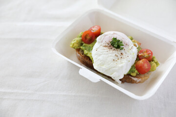 Wall Mural - Poached eggs with avocado on toast in white background