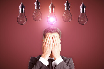 Aufkleber - Young european businessman covering eyes with abstract glowing row of light bulbs on red background. Idea, solution and innovation concept.