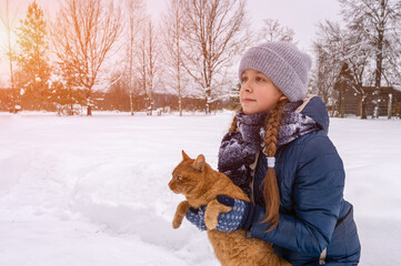 A girl strokes a red cat. Love for animals. Artistically colored and tinted photography