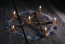Branch Pentagram - Witchcraft Tools Of Natural Wood. Wooden Pentagram With Lighted Candles In Circle Of Salt And Blue Petals. Occultism And Mysticism
