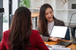 © Natee Meepian - Group of young business people brainstorming at a meeting starting a new business with blank white screen tablet