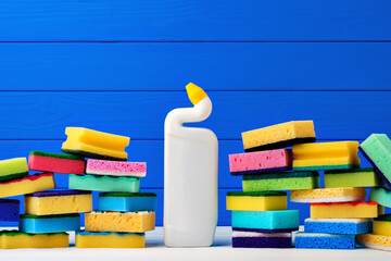 Wall Mural - Stack of new cleaning sponges and liquid detergent against blue wooden background