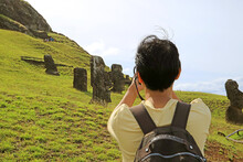 Traveler Taking Pictures Of Abandoned Massive Moai Statues Scattered On Rano Raraku Volcano, Former Moai Quarry On Easter Island Of Chile