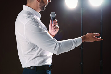 Wall Mural - Motivational speaker with microphone performing on stage, closeup