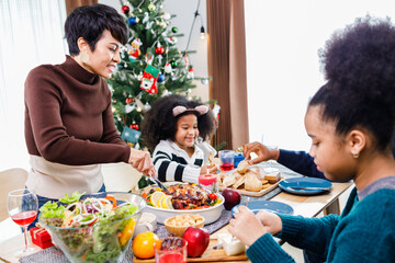 Happy family are having dinner at home. Celebration holiday and togetherness near Christmas tree. African American family. Merry Christmas.