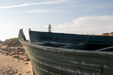 Boat Wreck In Front Of A Lighthouse In Andalucia