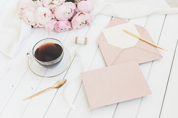 Wall Mural - Wedding greeting card concept. Top view mockup on wooden background with peonies flowers. Flat lay style in light colors.