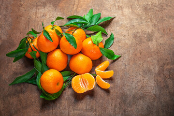 Wall Mural - Mandarin oranges fruits or tangerines with leaves on a wooden table. Copyspace. Fresh picked mandarins Top view. Flat lay.