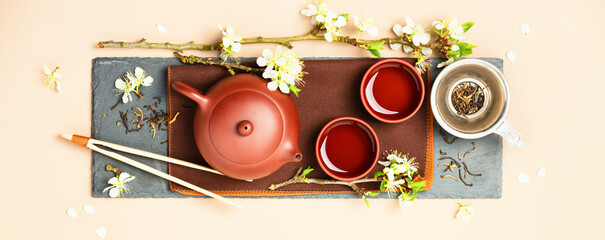 Canvas Print - Asian Tea set on stone slate board, ceramic teapot, cups, dried tea and spring branches