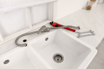 Canvas Print - Plumber's tools and water tap ready for installation near sink on countertop in kitchen