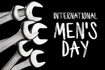 Wall Mural - International men's day concept. Steel wrenches isolated on black background with text