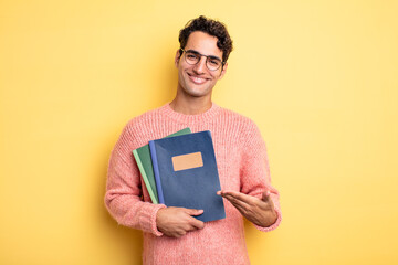 Wall Mural - young handsome man smiling cheerfully, feeling happy and showing a concept. notebook concept