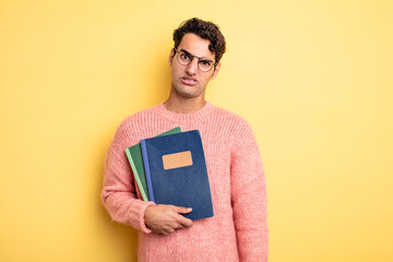 Wall Mural - young handsome man feeling puzzled and confused. notebook concept