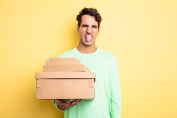 Wall Mural - young handsome man feeling disgusted and irritated and tongue out. package boxes