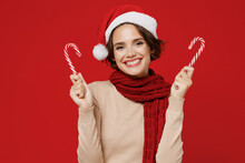 Young Smiling Fun Happy Caucasian Woman 20s Wear Santa Claus Christmas Red Hat Hold Candy Cane Stick Lollipop Isolated On Plain Red Background Studio Portrait. Happy New Year 2022 Celebration Concept.