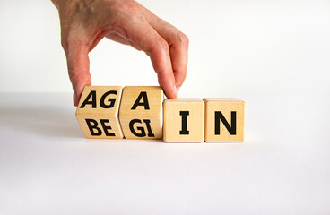 Wall Mural - Begin again symbol. Businessman turns wooden cubes and changes the word begin to again. Beautiful white table, white background. Business and begin again concept. Copy space.