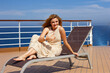 © rubchikova - Happy woman sits on a chair on the open deck of a cruise liner